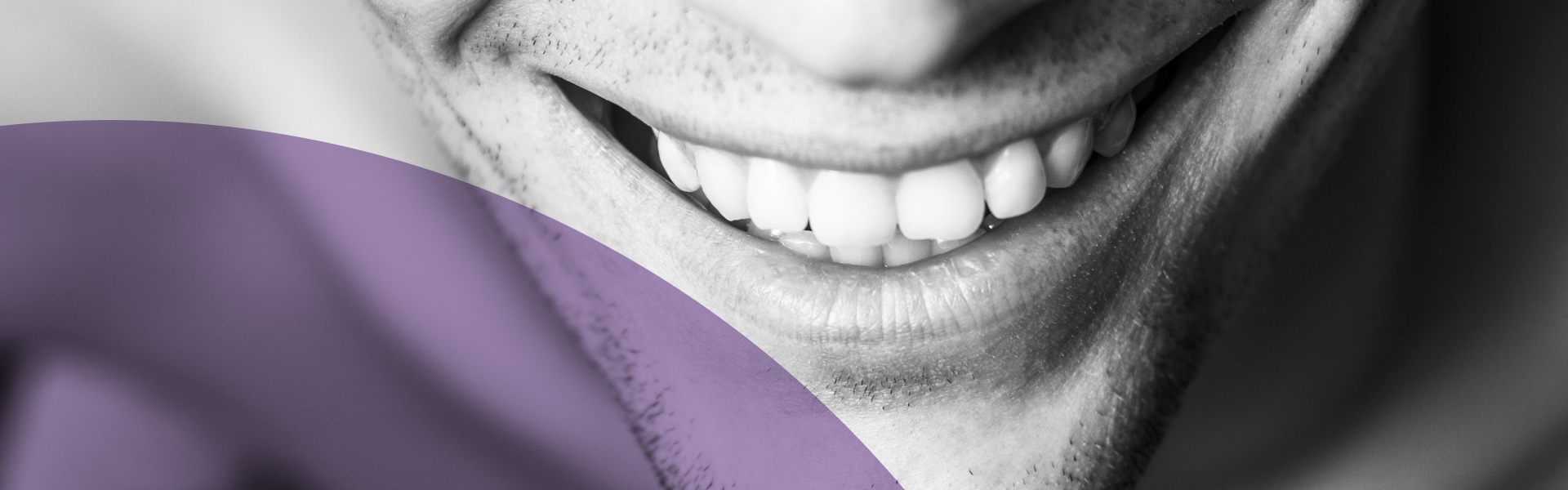 Ein Mann lächelt nach der Implantologie mit seinem Zahnersatz